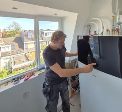 Monteur installeert de binnenunit van een Daikin warmtepomp in een zolderkamer