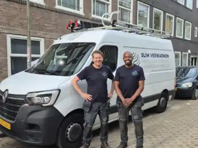 Twee monteurs van Slim Verwarmen voor hun werkbus geparkeerd in een straat in de Watergraafsmeer